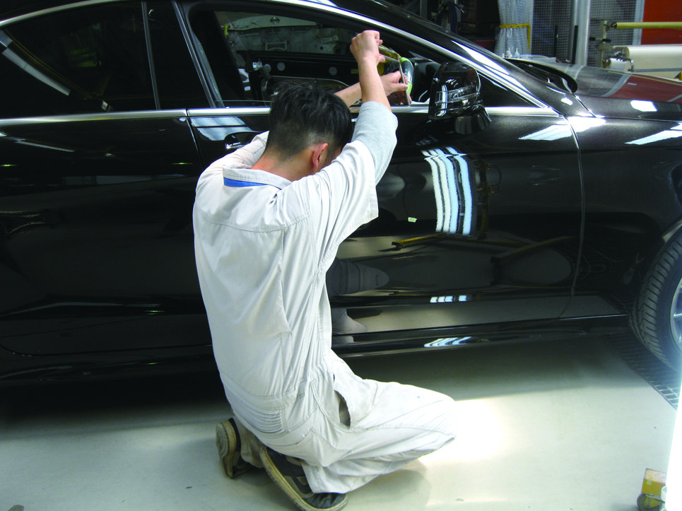 黒い車両　運転席のドア下側にデントリペア施工作業中