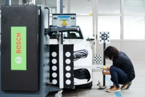 専用の作業場にて、白い車両にエーミング作業中