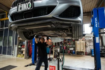 認証工場内で、車両の下回りを点検作業中